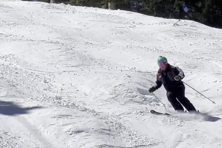 Sara, a mid-level skier, making a controlled turn